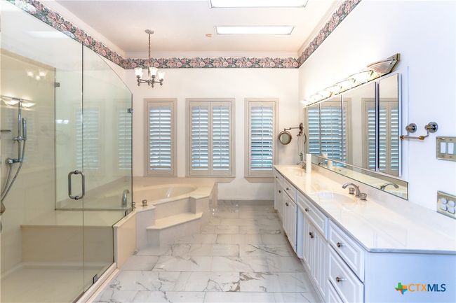Primary on suite bathroom featuring a garden tub and separate shower. Double sinks and marble floors | Image 19