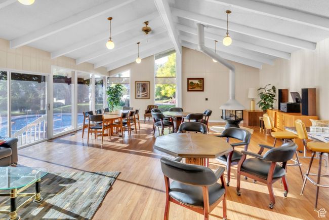 Dining space with wood finished floors and a wood stove | Image 32