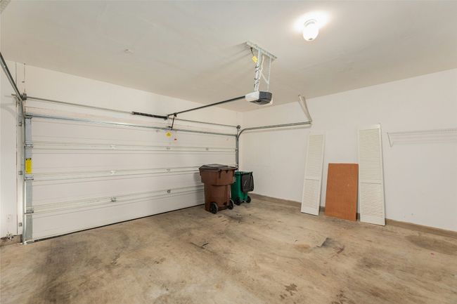 Garage featuring a garage door opener and baseboards | Image 25