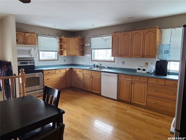Kitchen featuring backsplash, appliances with stainless steel finishes, sink, and light hardwood / wood-style flooring | Image 9