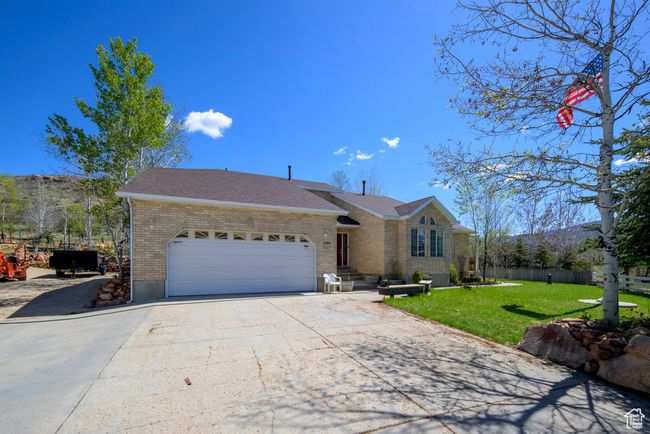 Single story home featuring a garage, a front lawn, fence, brick siding, and driveway | Image 61