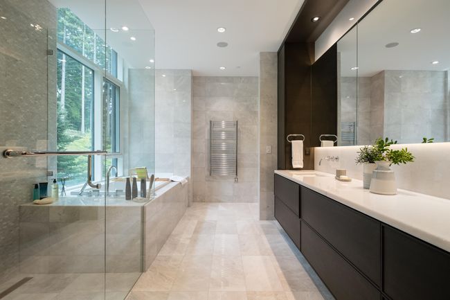 Full bathroom with tile walls, a towel warmer, vanity, healthy amount of natural light, and a garden tub | Image 24