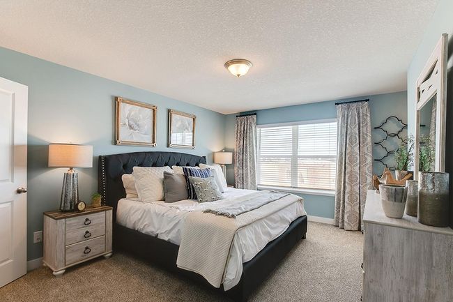 The primary bedroom, with enough space to accommodate a king sized bed. Model home photo, colors and selections may vary. | Image 9