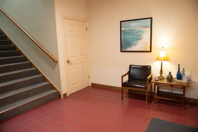 Sitting room with tile patterned floors, baseboards, and stairs | Image 4