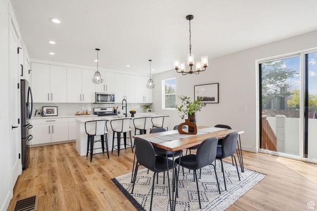 Dining area featuring recessed lighting, visible vents, light wood-type flooring, baseboards, and a notable chandelier | Image 7