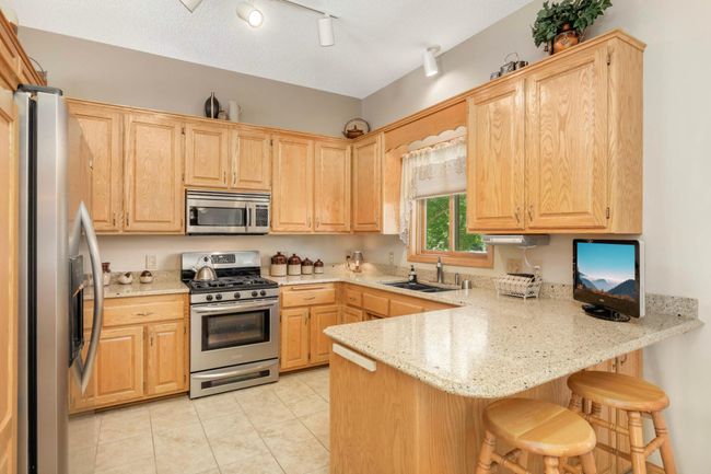 Eat-in kitchen with Cambria countertops, stainless steel appliances, and window looking out to the pond. | Image 4