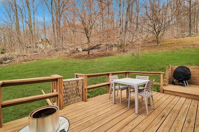 Wooden deck featuring a lawn, outdoor dining area, and area for grilling | Image 18