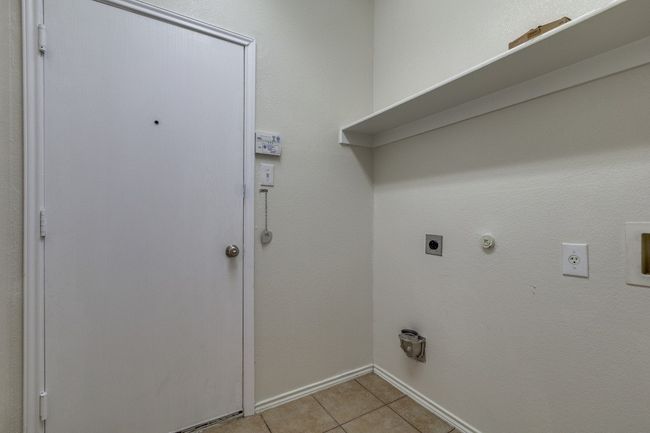 Laundry area featuring baseboards, hookup for a gas dryer, laundry area, electric dryer hookup, and light tile patterned flooring | Image 17