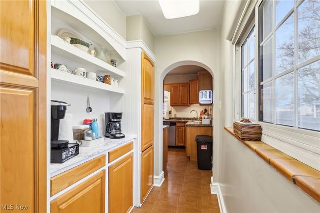 Bar with arched walkways, stainless steel dishwasher, baseboards, and white microwave | Image 10