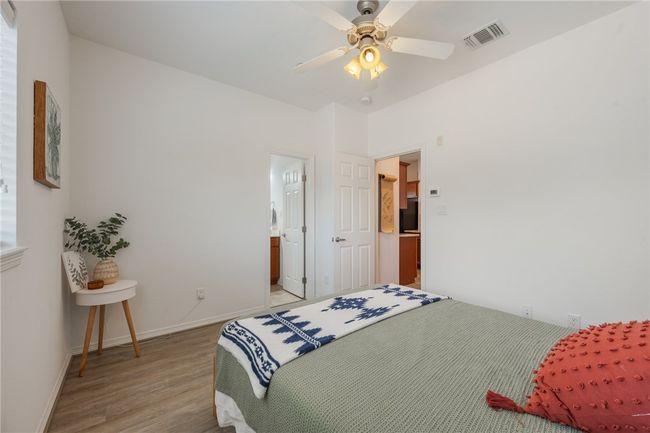 Bedroom with light wood-style floors, a ceiling fan, and ensuite bath | Image 12