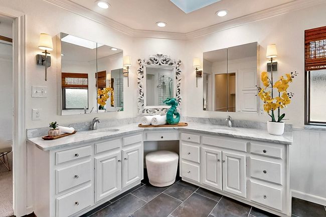Bathroom featuring double vanity, crown molding, tile patterned flooring, recessed lighting, and a skylight | Image 19