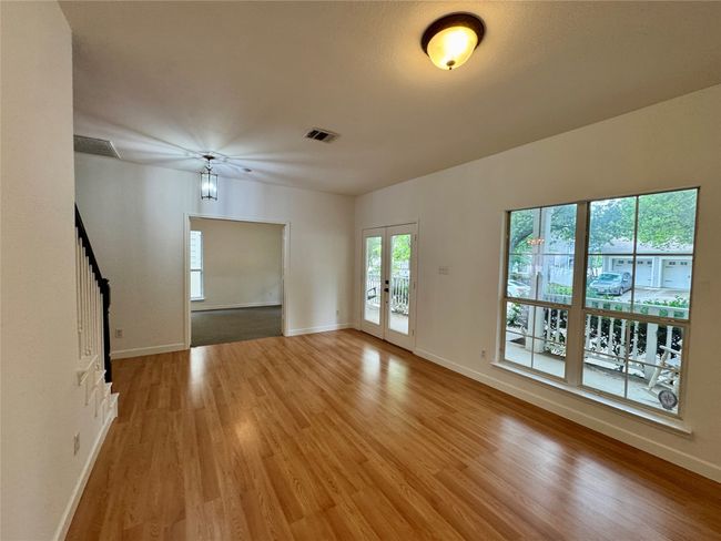 Empty room with light wood-style flooring, baseboards, french doors | Image 4