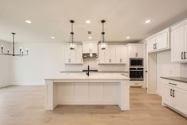 Kitchen with oven, under cabinet range hood, stainless steel microwave, tasteful backsplash, and recessed lighting | Image 11