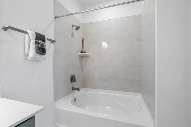 This primary bathroom also features this oversized tub and shower combination with tile surround. | Image 19