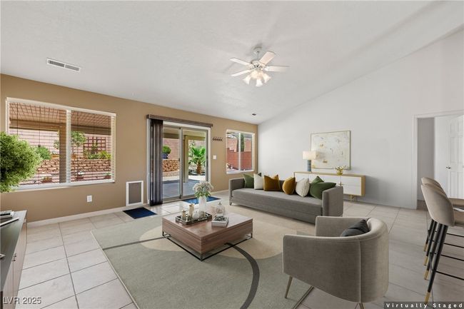 Living room with a ceiling fan, light tile patterned flooring, and lofted ceiling | Image 10