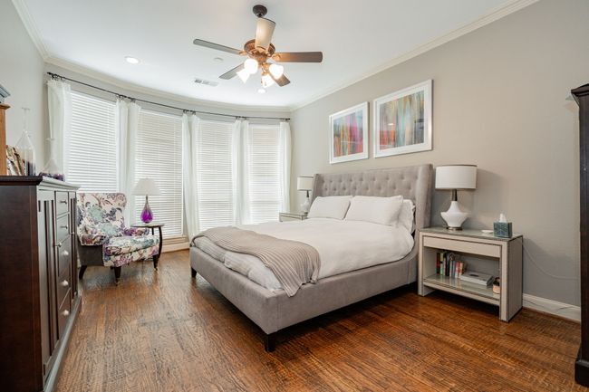 Bedroom with crown molding, ceiling fan, dark wood finished floors, visible vents, and recessed lighting | Image 18