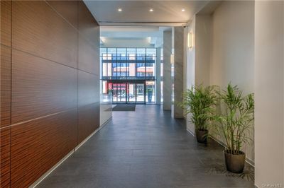 Hall featuring floor to ceiling windows and dark tile flooring | Image 2