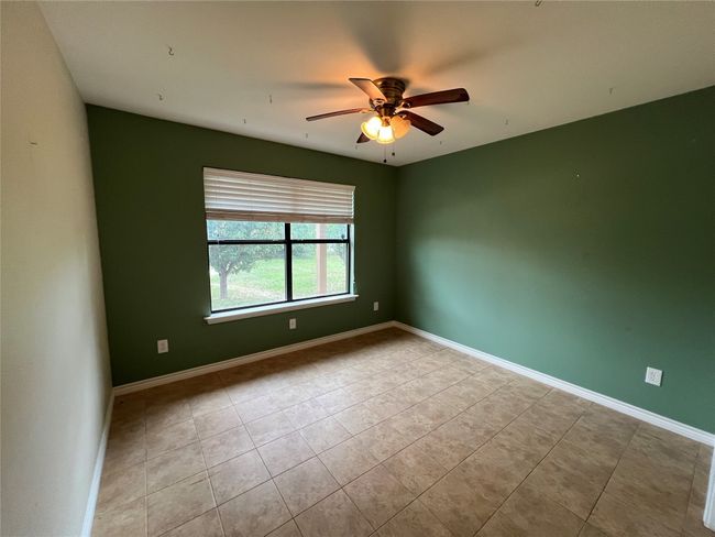 Empty room featuring tile patterned floors, a ceiling fan, and baseboards | Image 9
