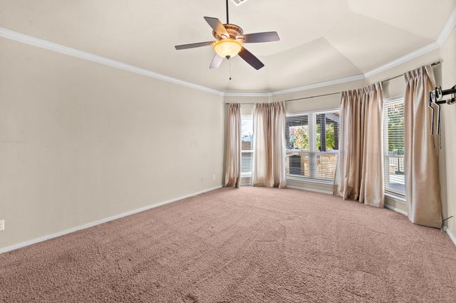 Carpeted empty room featuring a ceiling fan and crown molding | Image 15
