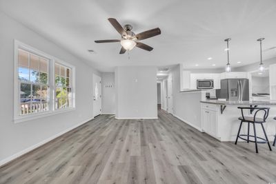 Unfurnished living room with light hardwood / wood-style floors and ceiling fan | Image 3