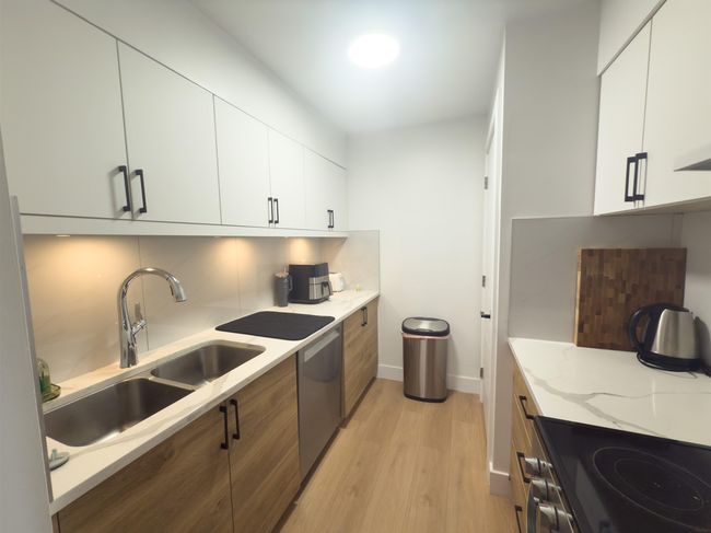Kitchen with a sink, backsplash, dishwasher, and light wood-style flooring | Image 9