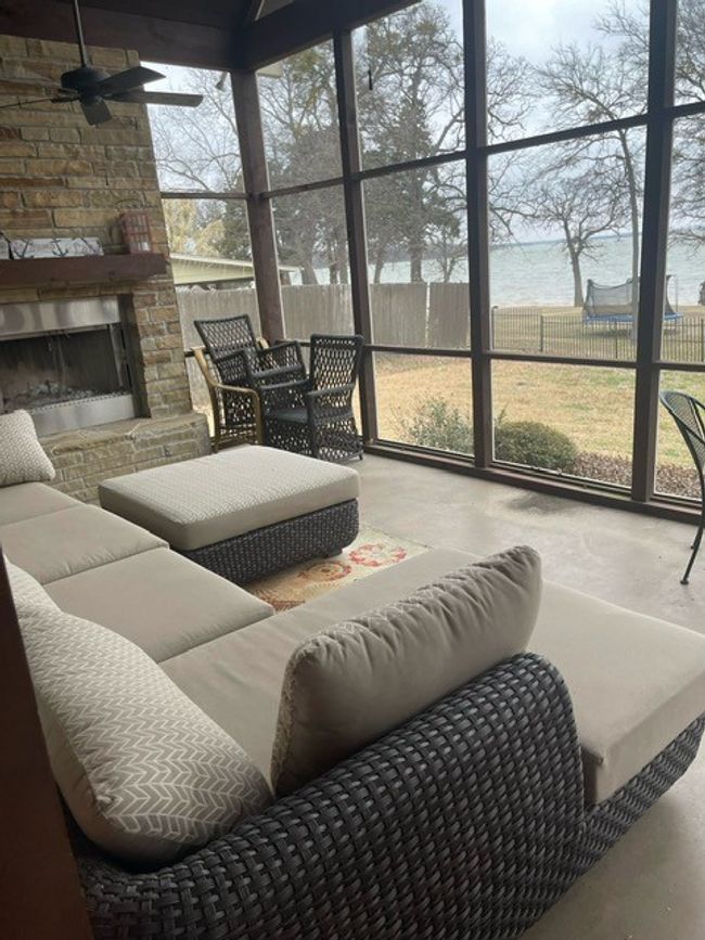 Sunroom / solarium featuring a water view, an outdoor living space with a fireplace, ceiling fan, and a wealth of natural light | Image 5