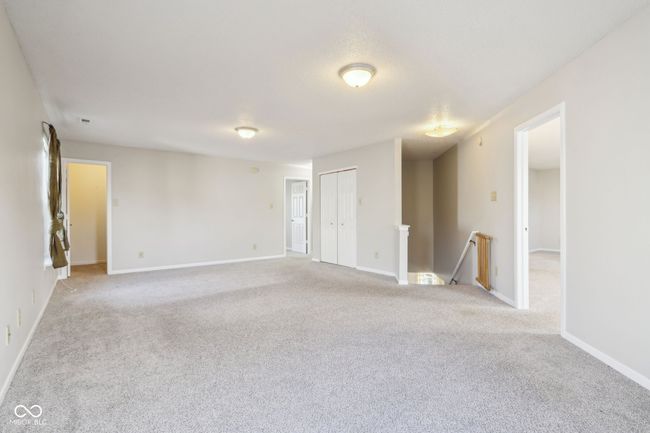 unfurnished room featuring light colored carpet, baseboards, and radiator heating unit | Image 51