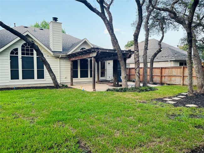 Back of house featuring a patio with oak shaded pergola. Large fenced yard | Image 22