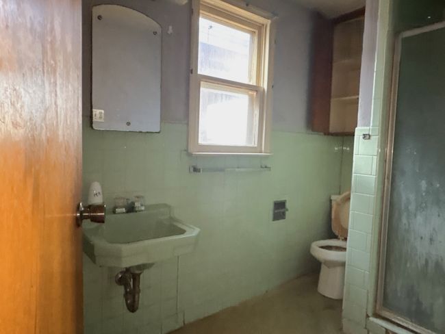 Bathroom with toilet, tile walls, and a shower stall | Image 7