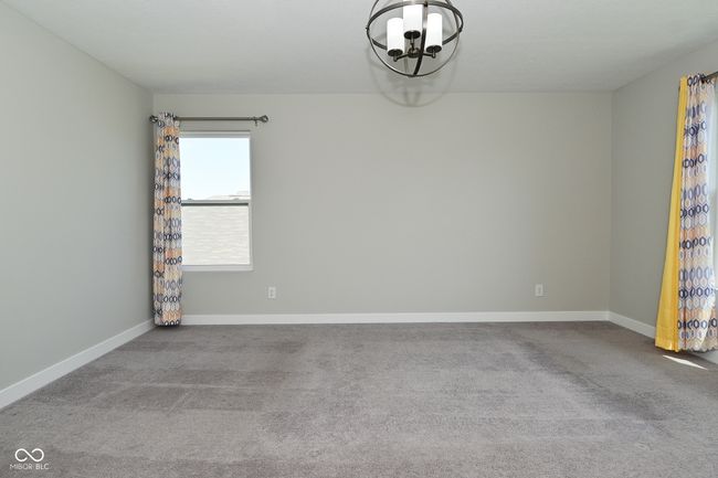 carpeted spare room featuring a notable chandelier and baseboards | Image 40