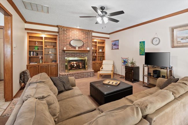 Spacious family room features floor-to-ceiling brick fireplace with gas logs. Notice the gorgeous built-ins on each side of the fireplace perfect for creating a library of your favorite books or displaying your favorite family heirloom collectibles. | Image 22