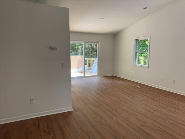 Empty room featuring plenty of natural light, dark wood finished floors, and lofted ceiling | Image 5