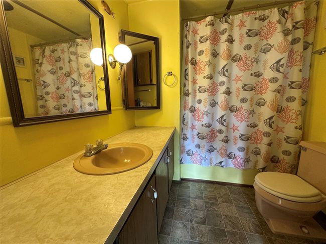 Full bath with stone finish floors, toilet, vanity, and shower / bath combo | Image 11