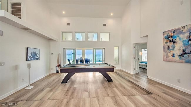 Playroom with light wood finished floors, billiards table, a high ceiling, and recessed lighting | Image 9