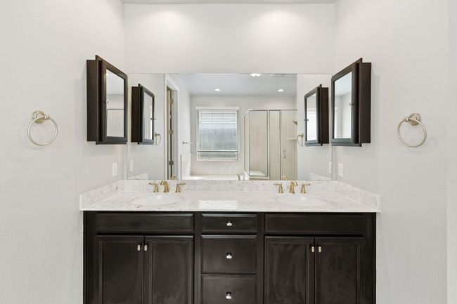 Full bathroom featuring double vanity, a sink, and a shower stall | Image 22