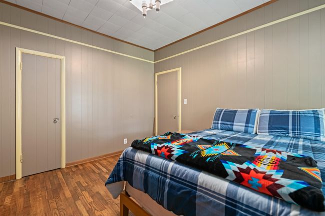 Bedroom featuring wood finished floors, ornamental molding, and baseboards | Image 18
