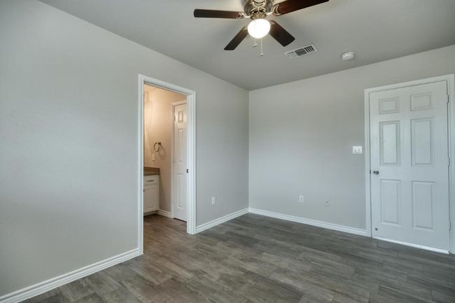 Spare room with ceiling fan and dark wood-style floors | Image 11