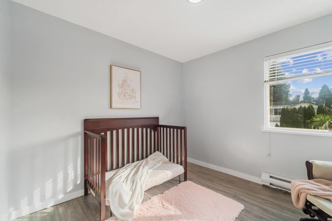 Bedroom with a baseboard heating unit, baseboards, and wood finished floors | Image 16