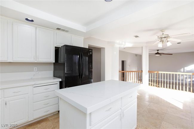 Kitchen with white cabinetry, visible vents, freestanding refrigerator, and a ceiling fan | Image 17