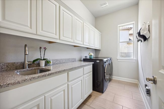 Laundry room with visible vents, baseboards, a sink, cabinet space, and separate washer and dryer | Image 29
