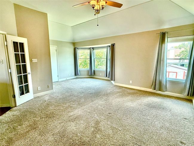 Carpeted spare room featuring vaulted ceiling and a ceiling fan | Image 15