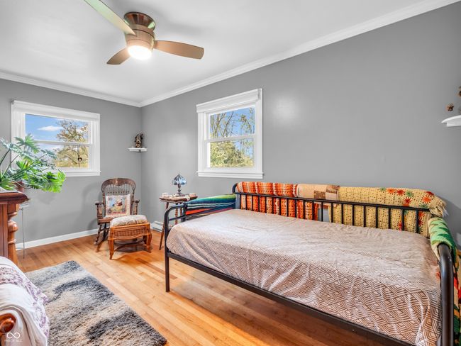 bedroom with baseboards, wood finished floors, multiple windows, and crown molding | Image 24
