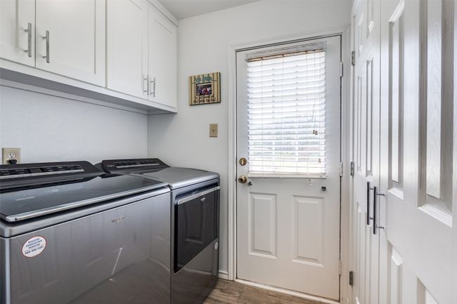 Laundry room featuring independent washer and dryer, cabinet space, and wood finished floors | Image 13