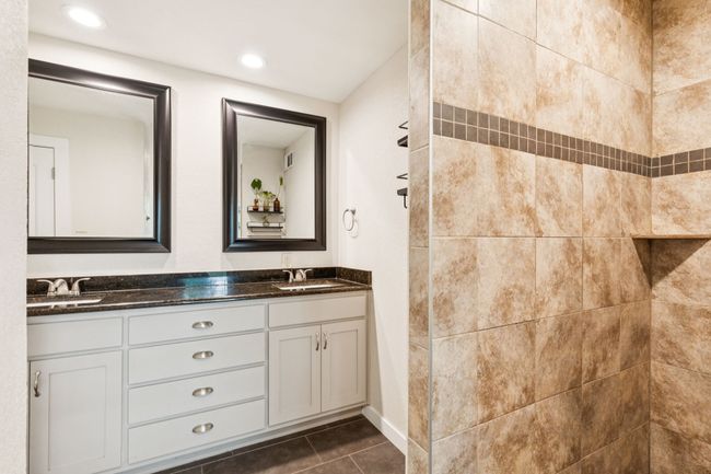 Ensuite bathroom with double vanity, a tile shower, and an oversized walk in closet. | Image 17