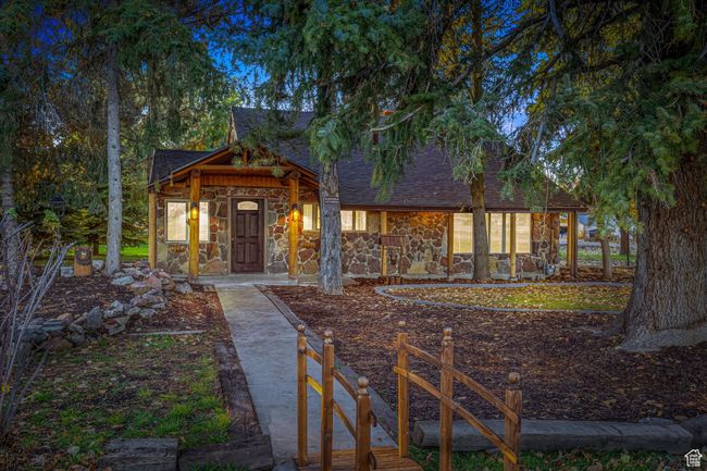 Rustic home featuring stone siding and roof with shingles | Image 6