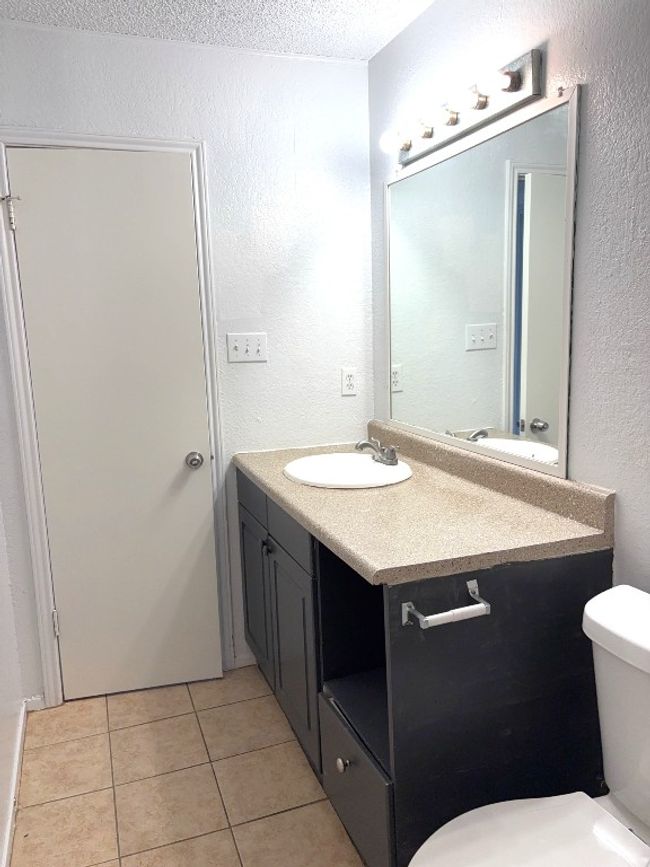 Bathroom featuring vanity, tile patterned flooring, a textured wall, and a textured ceiling | Image 11
