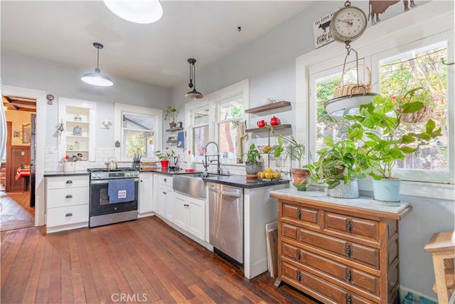 Remodeled farmhouse-style kitchen with gas range, utility sink, and plenty of cabinet space. | Image 14