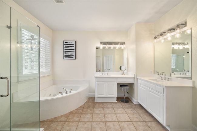 Bathroom with a stall shower, two vanities, a sink, and a tub with jets | Image 17