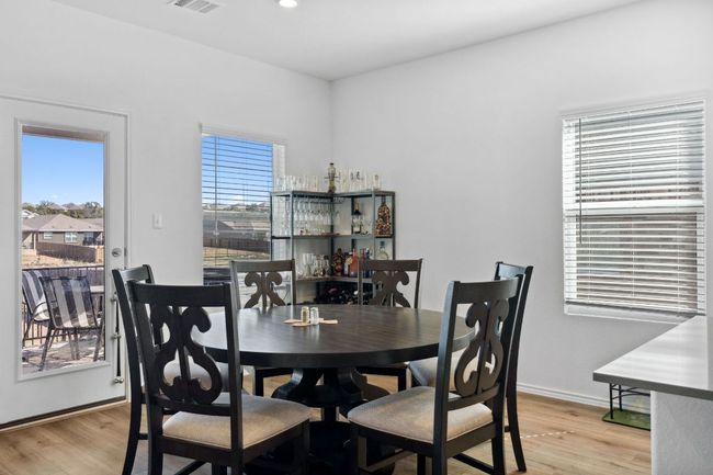Dining space featuring light wood finished floors, baseboards, and visible vents | Image 14