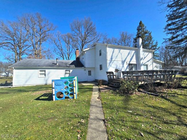 Rear view of house with a lawn, a chimney, and a deck | Image 9